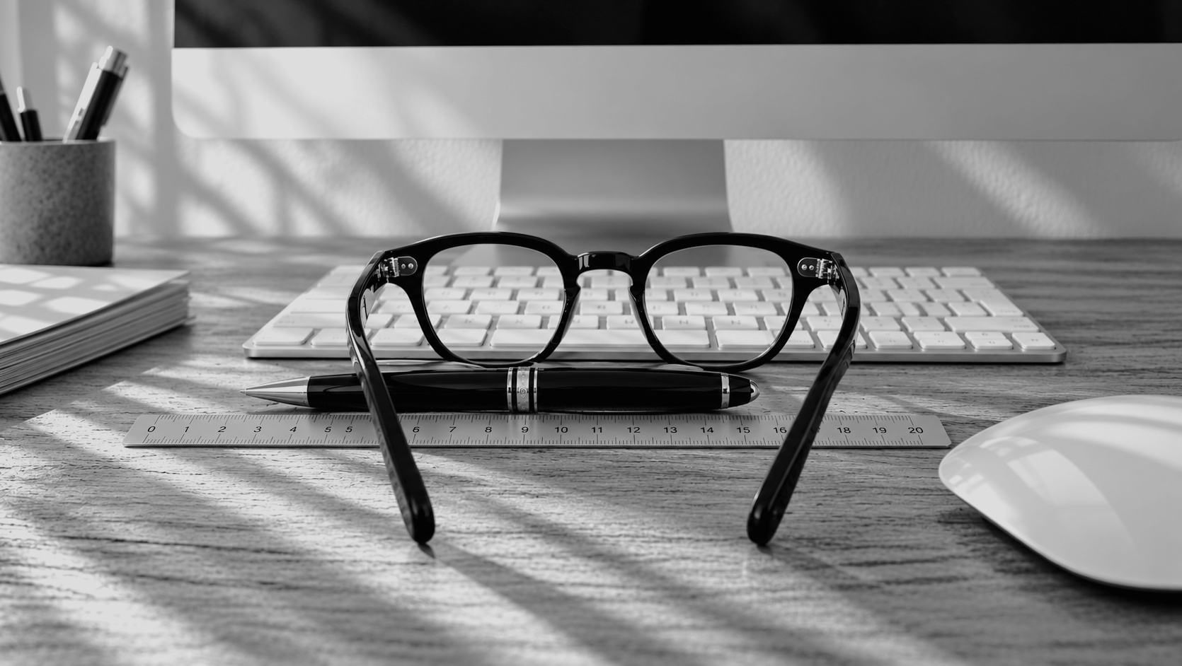 Occhiali, penna e righello sulla scrivania di lavoro